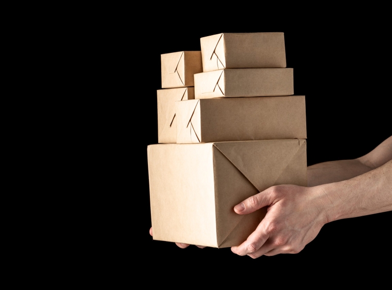 handing over parcels in wrapping paper isolated on black background